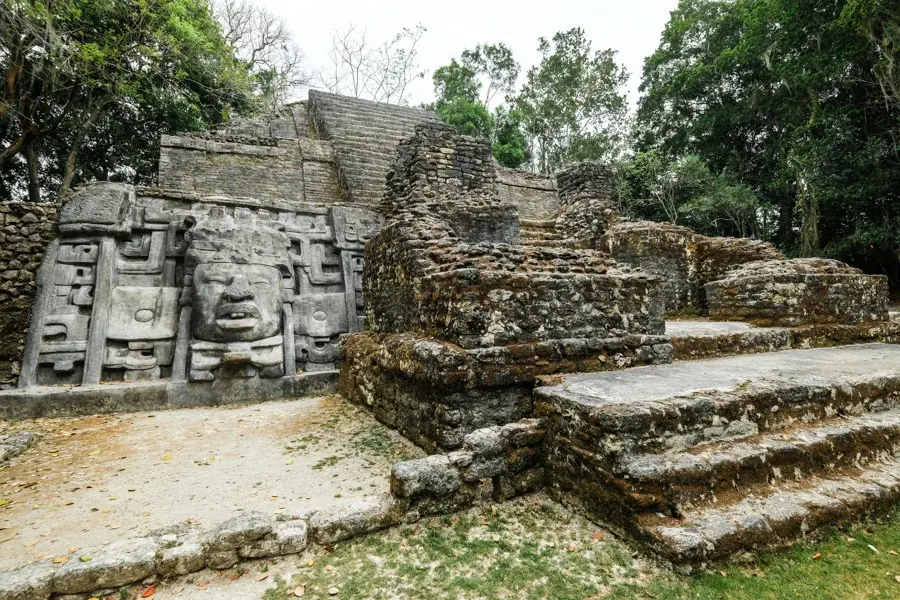 Carved stone masks and temple steps at Lamanai Maya ruins