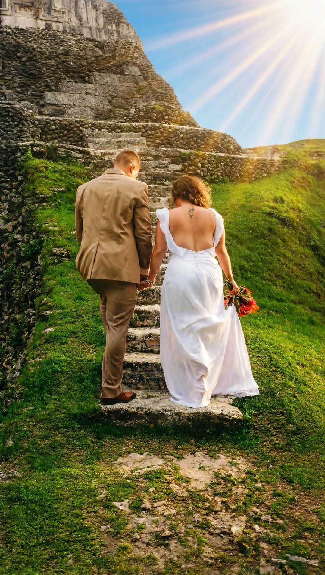 Bride and groom on ancient Maya stone steps at golden hour