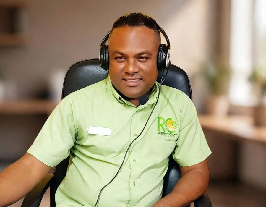 Roberto Garcia of RGs Travel Belize wearing a headset at his desk